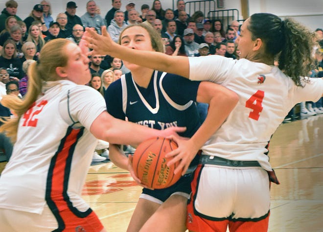 West York's Faith Walker, center, looks to drive past York Suburban defenders Paige Garner (42) and Janay Rissmiller (4) during the District 3 Class 5A girls' basketball semifinals on Tuesday, Feb. 27, 2024, at York Suburban High School. The host Trojans emerged with a thrilling 37-34 victory.