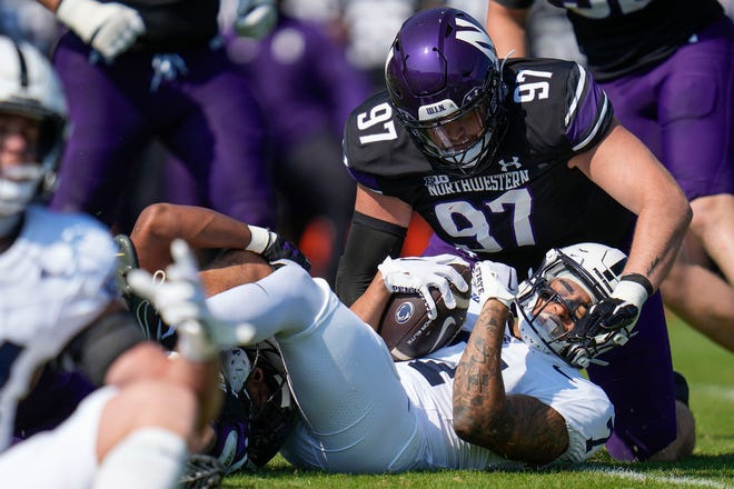 Northwestern defensive lineman Sean McLaughlin tackles Penn State wide receiver Kaden Saunders, bottom, during the first half of an NCAA college football game, Saturday, Sept. 30, 2023, in Evanston, Ill. (AP Photo/Erin Hooley)