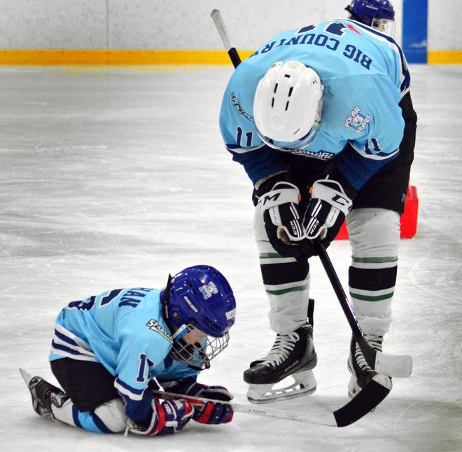 York College hockey player Nolan Johnson, right, checks on his teammate during the third annual charity hockey game featuring the York Polar Bears and the York College ice hockey team on Sunday, March 24, 2024 at the York Ice Arena.