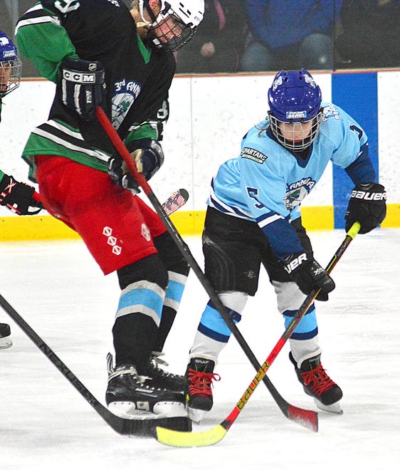 Carmalyn Hyser, right, battles Gage Moldovan for the puck during the third annual charity hockey game featuring the Polar Bears and the York College ice hockey team on Sunday, March 24, 2024 at the York Ice Arena.
