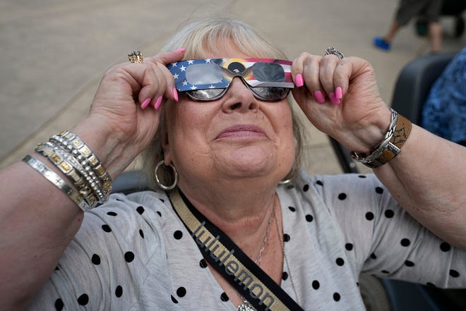 Karen Haun, of Lantana, Texas, uses solar glasses to watch beginning of a solar eclipse, as seen from Fort Worth, Texas, Monday, April 8, 2024. (AP Photo/LM Otero)