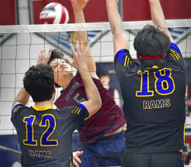 New Oxford's Zackary Topper spikes the ball as Kennard-Dale's Cole Yates (12) and Andy Ester (18) go for the block during York-Adams League boys' volleyball action Thursday, April 11, 2024, at New Oxford. The Colonials swept the Rams, 3-0.