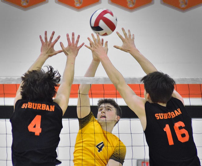 Red Lion's Tyler Good, center, blasts the ball past York Suburban's Kyan Stockman (4) and Truett Miller (16) during York-Adams League boys' volleyball action Wednesday, April 17, 2024, at York Suburban High School. The visiting Lions earned a 3-0 sweep of the Trojans.