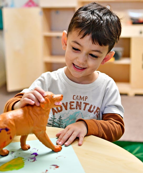 One of nine children currently enrolled in the daycare program paints with the paws of a toy dog in the classroom at WeeConnect Early Learning Center in Spring Garden Township, Tuesday, April 16, 2024. The nonprofit is currently raising funds to expend into a space that would allow 30-40 children to be enrolled in the inclusive learning program. (Dawn J. Sagert/The York Dispatch)