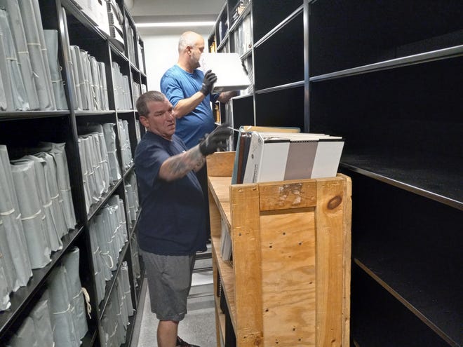 Workers with Armstrong Relocation Services in Lancaster place archival material on shelves at the new York County History Center on North Pershing Avenue. The movement of archived documents and other materials should be completed by next week.