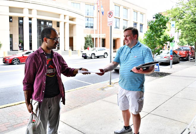 Write-in candidate for York City School Board Ryan Supler, right, hands a flyer to voter Josue Estrada-Laboy, of York City, during Primary Election Day at the Appell Center for the Performing Arts polling location in York City, Tuesday, May 16, 2023. Dawn J. Sagert photo